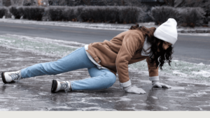 Woman slipping on ice during winter, illustrating the risk of slips, trips, and falls in icy conditions.